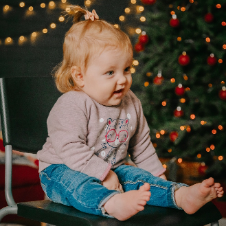 young child next to holiday decorations